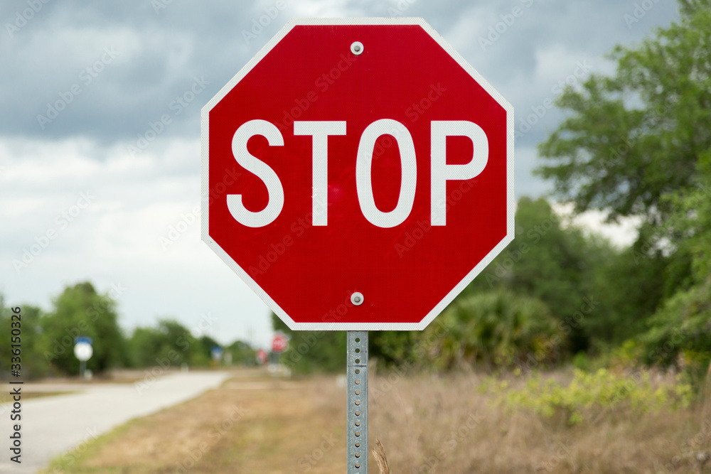 Stop sign on a road (USA/North American road sign) Stock Photo 