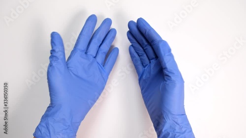 Doctor or nurse putting on blue nitrile surgical gloves, professional medical safety and hygiene for surgery and medical exam, protection against infection.