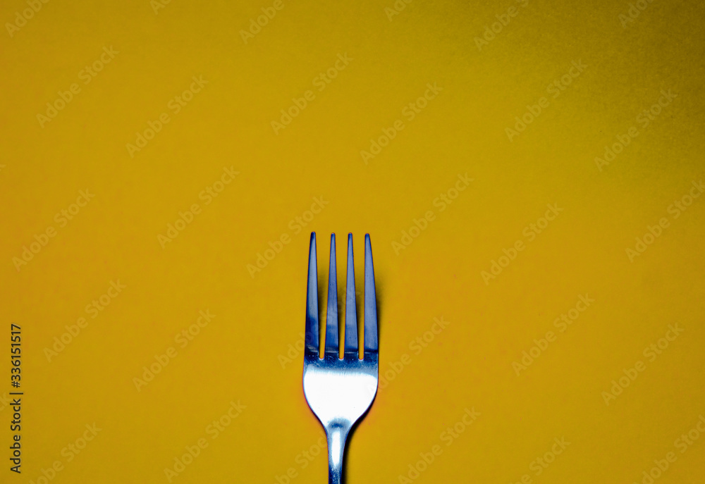 Fork on yellow background. Backgrounds for food Fork on yellow background. Backgrounds for food