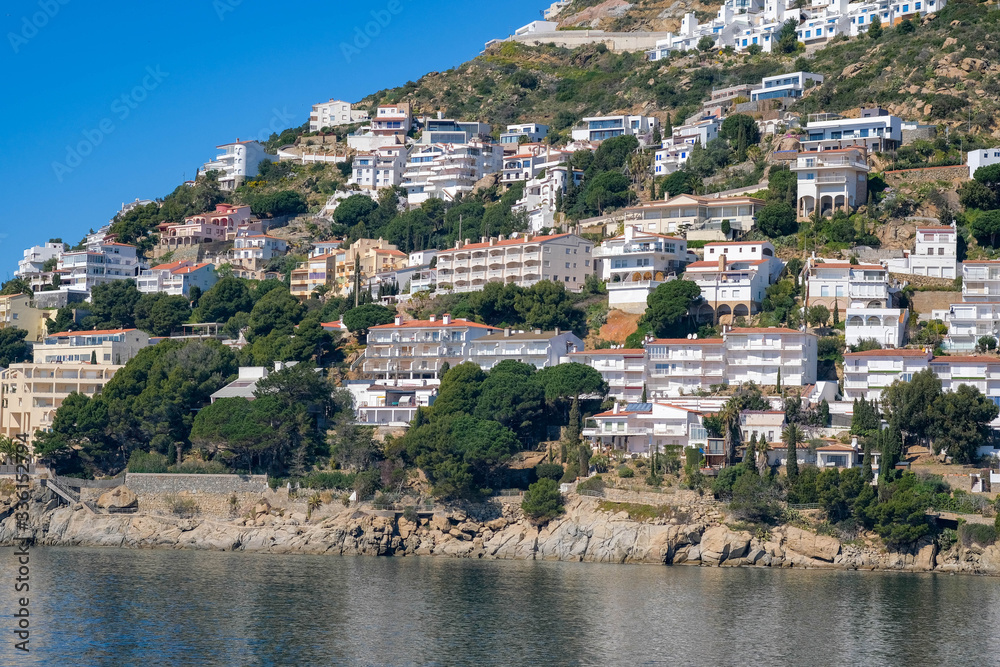 View on the wonderful resort town. Classic Spanish white houses on mountains. Amazing resort destination. Mediterranean resort on a sunny day. Paradise bays, calm blue sea, beach.