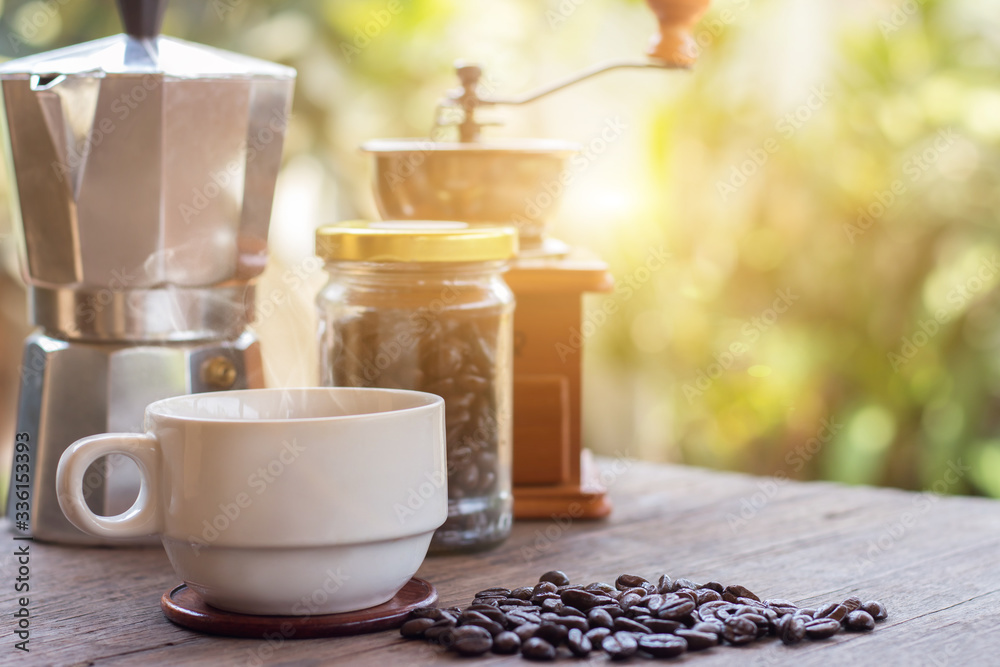 A cup of hot espresso coffee mugs and roasted coffee beans with moka pot placed on wooden floor background,coffee morning,selective focus A cup of hot espresso coffee mugs and roasted coffee beans with moka pot placed on wooden floor background,coffee morning,selective focus