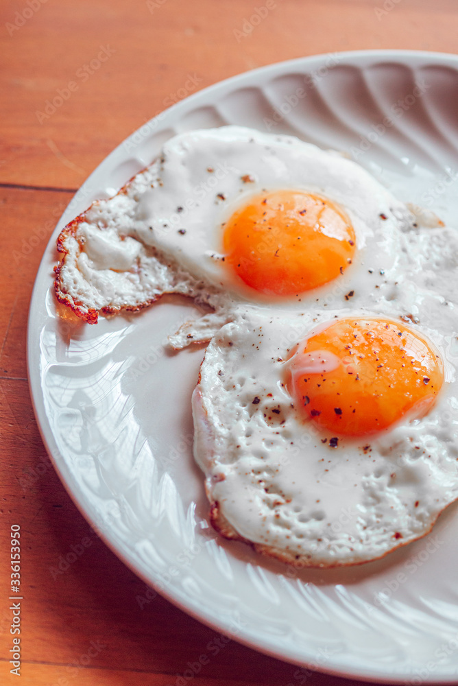 Fried eggs with salt and pepper on a plate Fried eggs with salt and pepper on a plate