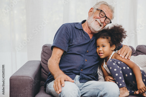 Grandfather embraces hug love for the little girl niece in a warm family home.