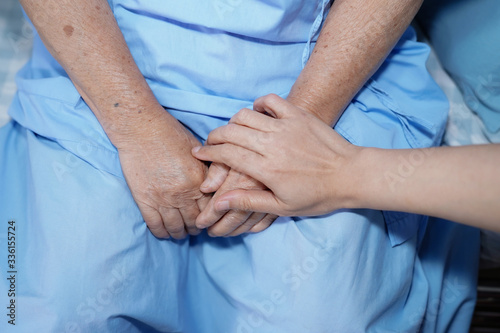 Touching hands Asian senior or elderly old lady woman patient with love, care, helping, encourage and empathy at nursing hospital ward : healthy strong medical concept