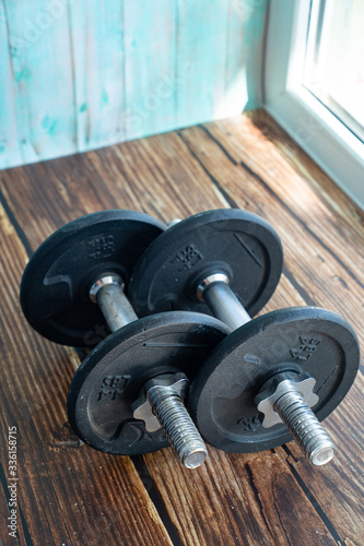 Black dumbbells sports equipment on wooden 