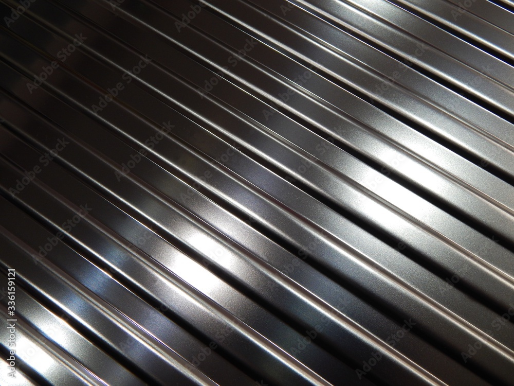 Abstract metal background.Metallic plate texture.Diagonal silver grey stripes wallpaper banner design.Corrugated metal plate background. Abstract metal background.Metallic plate texture.Diagonal silver grey stripes wallpaper banner design.Corrugated metal plate background.