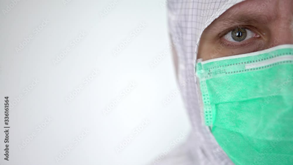 4K, close-up portrait of confident male caucasian doctor wearing a protective suit and surgical mask isolated on white background. Medical and health care concept, Biological hazard. Corona virus-Dan 4K, close-up portrait of confident male caucasian doctor wearing a protective suit and surgical mask isolated on white background. Medical and health care concept, Biological hazard. Corona virus-Dan