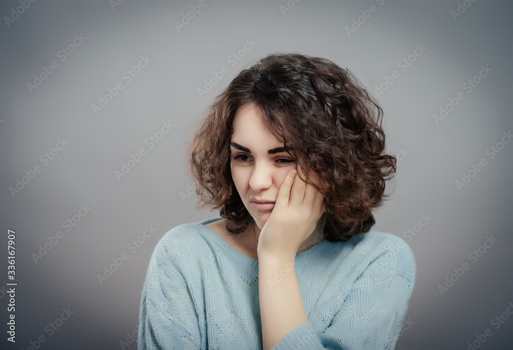 Beautiful sad casual lady isolated on gray background Beautiful sad casual lady isolated on gray background