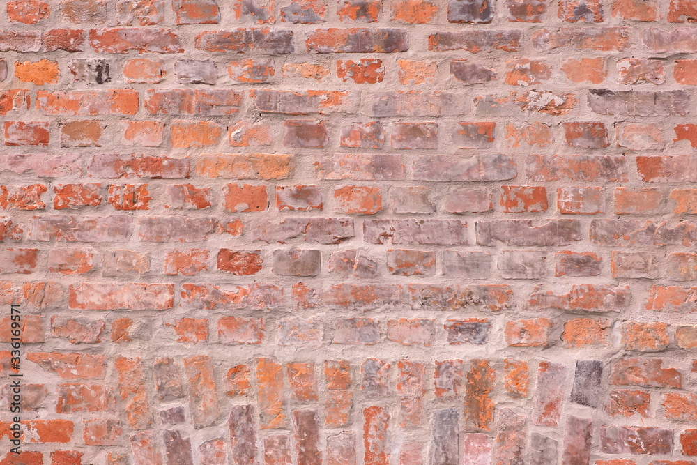 Surface of red brick wall, with some aged cracks in bricks structure