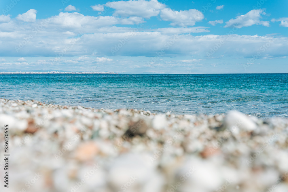 stones on the beach with a blue sea and blue sky on background stones on the beach with a blue sea and blue sky on background
