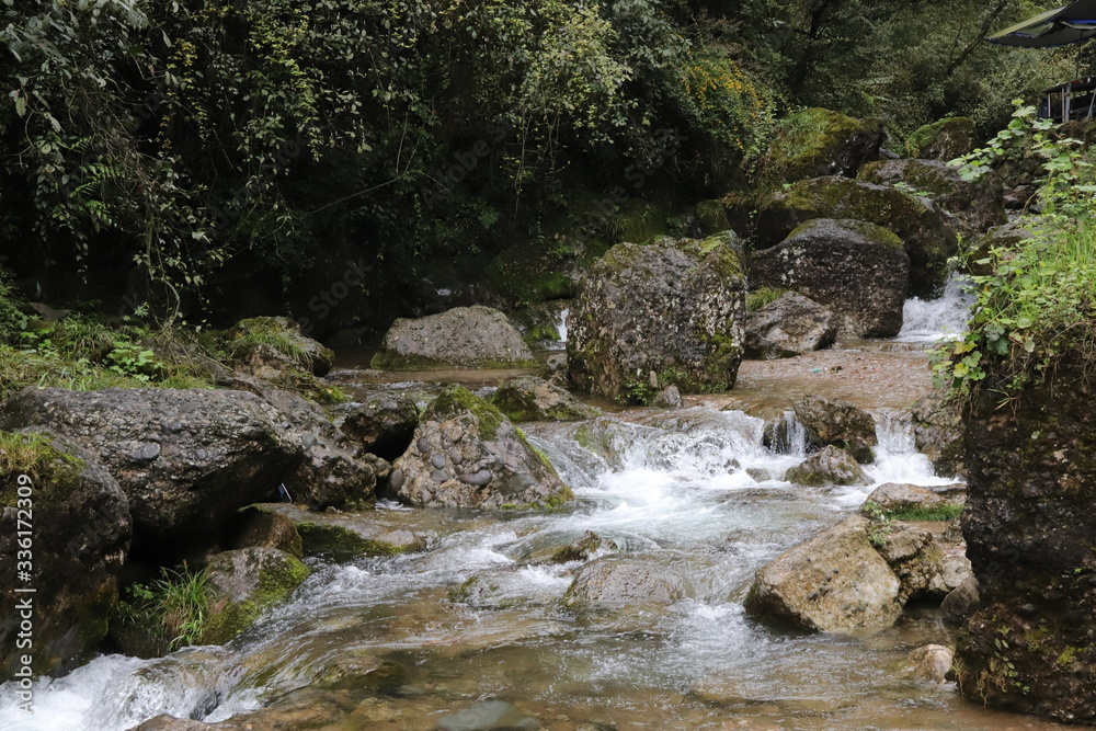 Beautiful landscape of river falls over mossy rocks, stones cover with moss, in a Mountain in Sichuan, China Beautiful landscape of river falls over mossy rocks, stones cover with moss, in a Mountain in Sichuan, China
