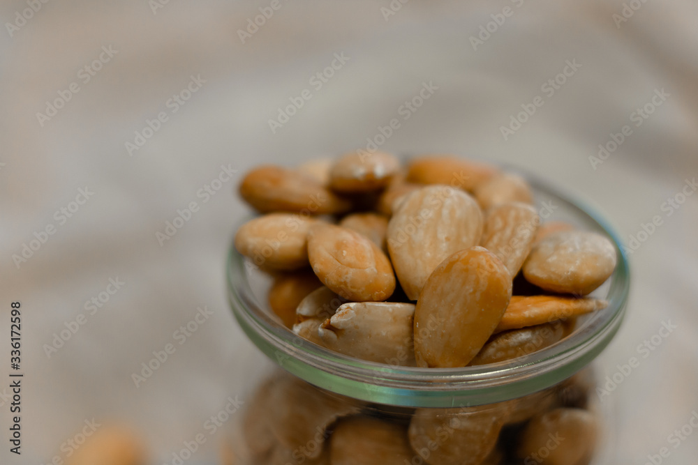 Fototapeta premium Bowl of toasted almonds on a gray background