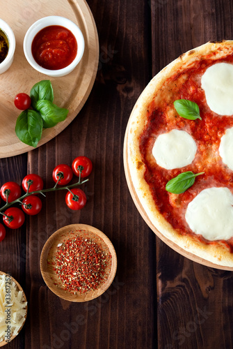 Traditional margarita pizza. Pizza with mozzarella, basil and tomatoes. Top view. Pizza sauce, cherry tomatoes, cheese