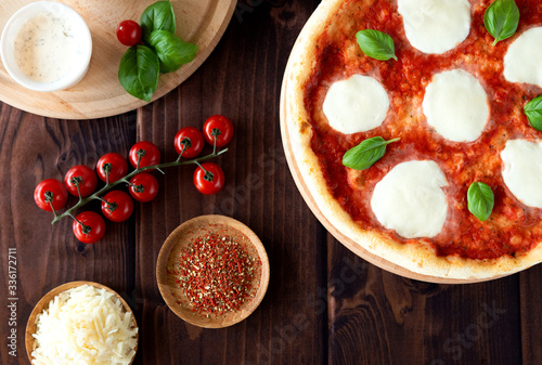 Traditional margarita pizza. Pizza with mozzarella, basil and tomatoes. Top view. Pizza sauce, cherry tomatoes, cheese