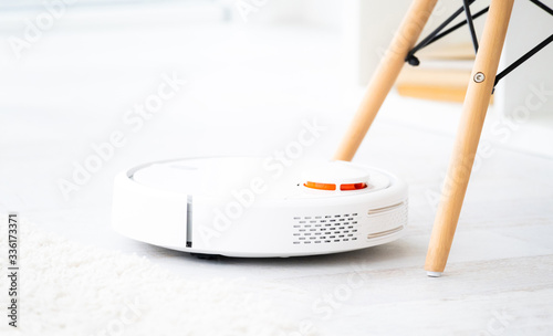 White robotic vacuum cleaner on a floor