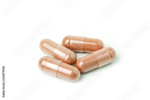capsules of Finely ground dry Turmeric isolated on white background.