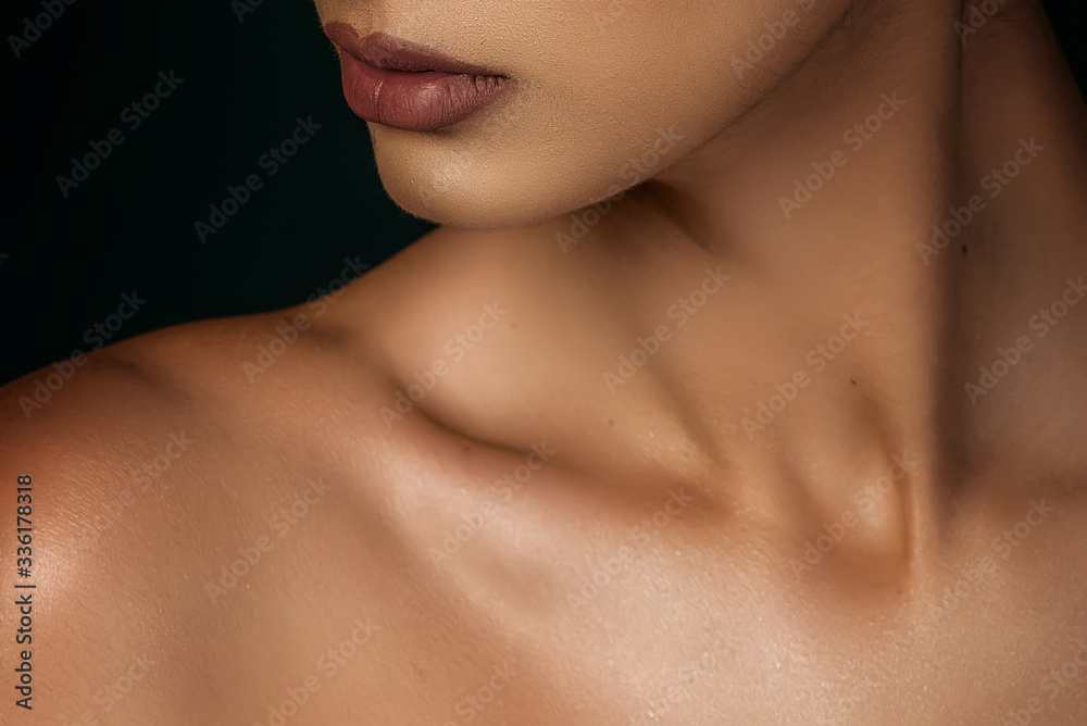 woman's neck and lips on a dark background