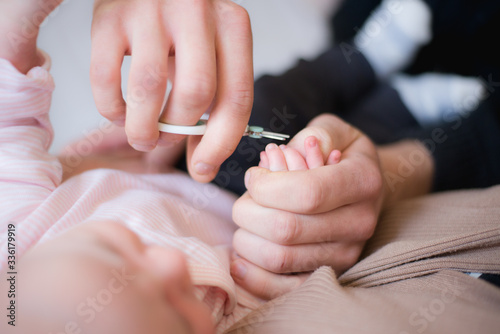 A parent cutting nails of a newborn close up