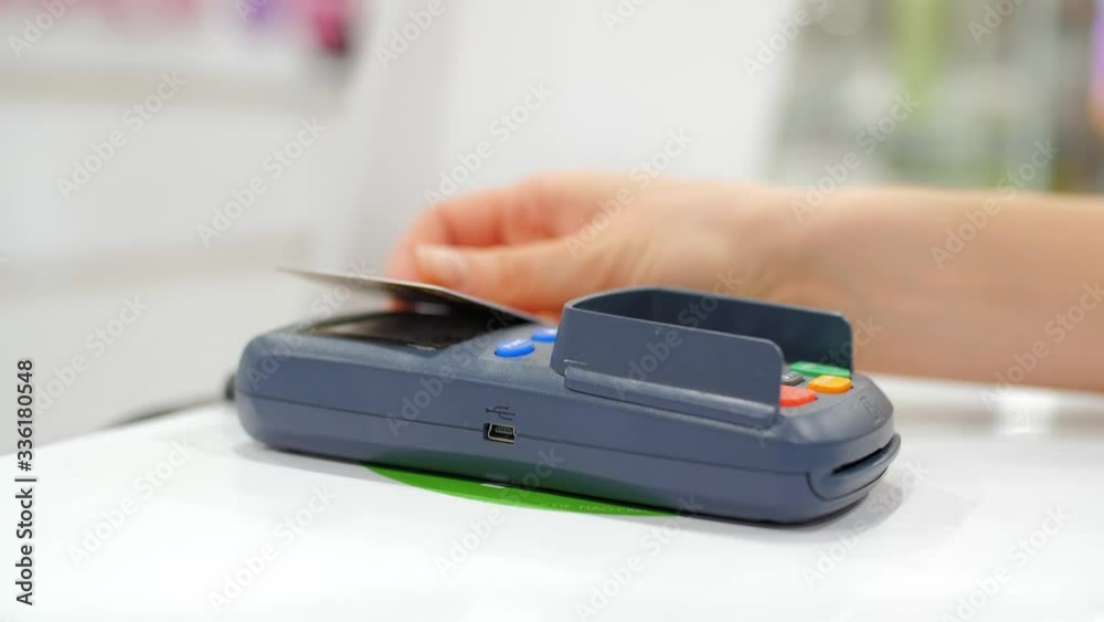NFC technology. Close-up of young woman using credit card with NFC chip on bank terminal. Customer paying for food order outdoor. NFC technology. Close-up of young woman using credit card with NFC chip on bank terminal. Customer paying for food order outdoor.