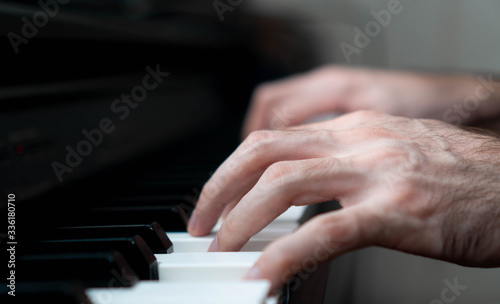 hands of a man playing the piano during the day, stylish photo