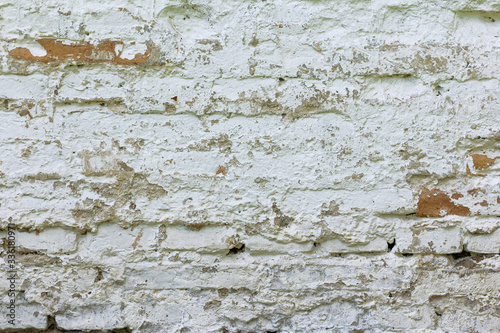 The brick wall is whitewashed, cracked old.