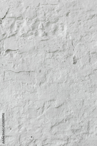 The brick wall is whitewashed, cracked old.