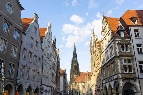 Germany, North Rhine-Westphalia, Munster, Tower of Saint?Lamberts Church between rows of residential buildings at Prinzipalmarkt square photo