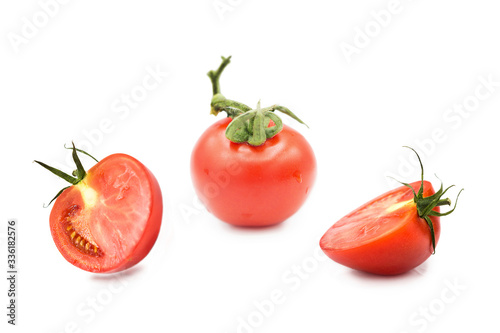Ripe fresh organic tomato and two halves of a tomato in the drops of dew isolated on a white background	