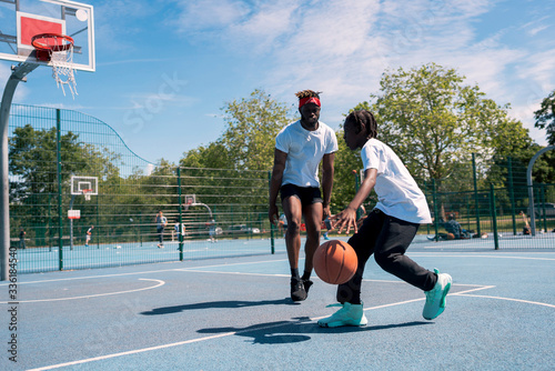 Father and son playing basketball on basketball court photo