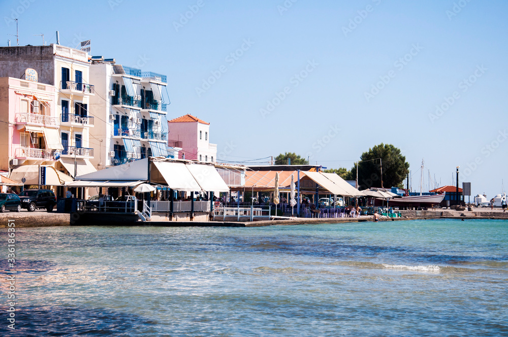 Landscape of calm coast in summer, with old and picturesque houses, on the turquoise sea of the Mediterranean in Greek islands, Greece Landscape of calm coast in summer, with old and picturesque houses, on the turquoise sea of the Mediterranean in Greek islands, Greece