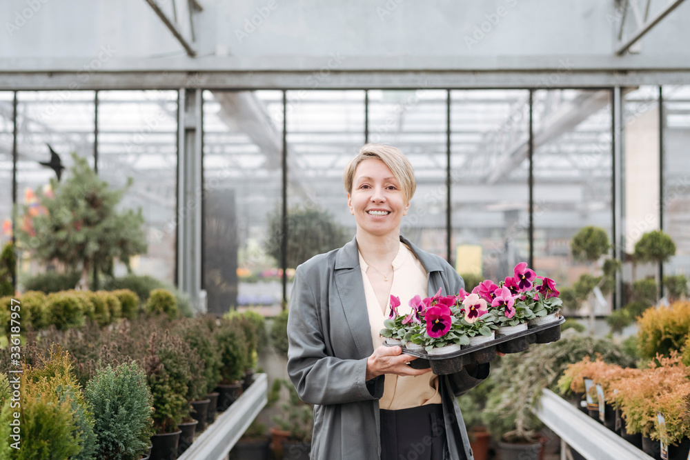 Smiling woman with pansies in flower shop Smiling woman with pansies in flower shop