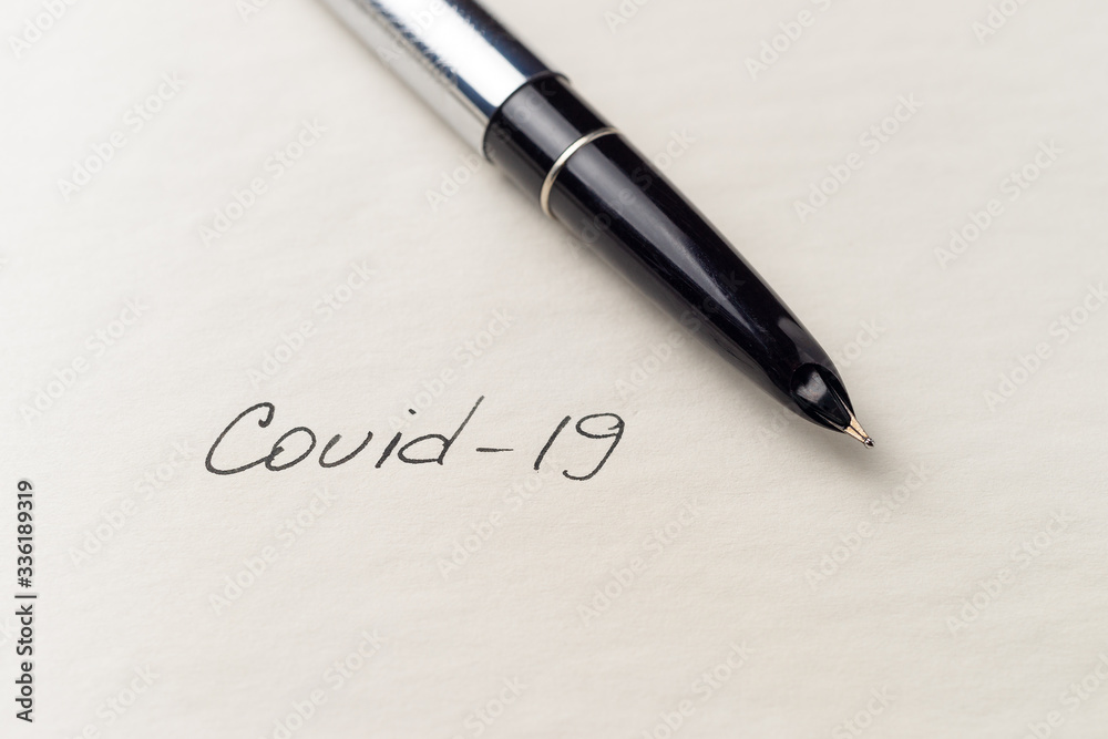 Covid-19 coronavirus inscription on a blank empty sheet of paper in a notebook. Nearby lies a pen. A lot of space for inscriptions and copyspace. Blank for inscriptions. Template for article or cover. Covid-19 coronavirus inscription on a blank empty sheet of paper in a notebook. Nearby lies a pen. A lot of space for inscriptions and copyspace. Blank for inscriptions. Template for article or cover.