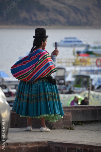 Kobieta w tradycyjnym boliwijskim stroju używa smartfon