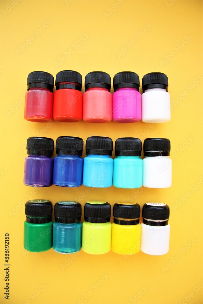 colorful paint in small jars on a yellow background bright background beautiful screensaver colorful paint in small jars on a yellow background bright background beautiful screensaver