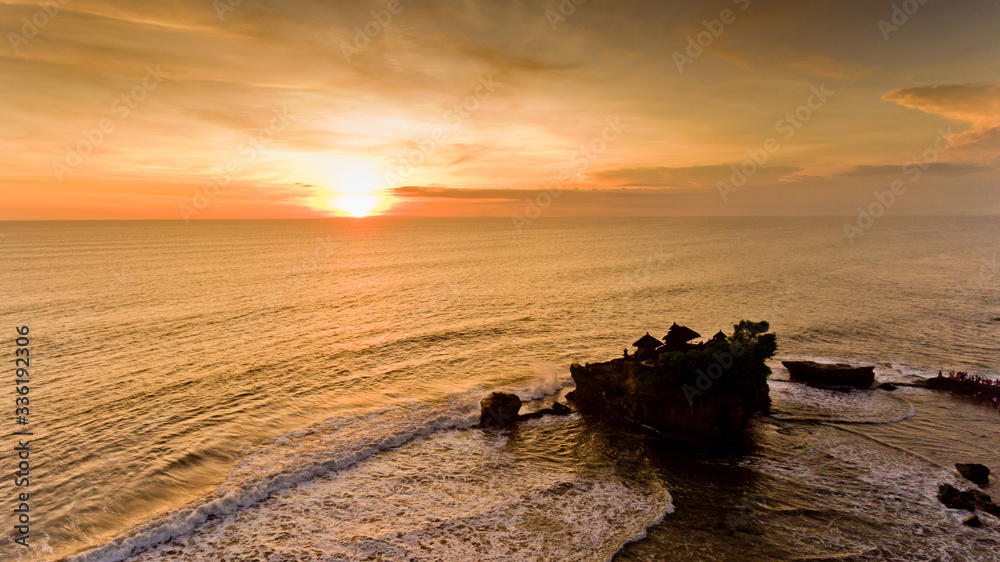 Sunset in the sea in the temple of Tanah Lot, Bali, Indonesia. Aerial view.