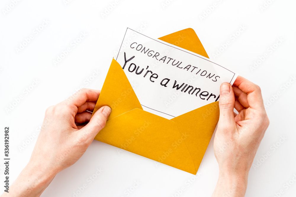 Congratulations You're a winner. Hands holding envelope with letter. White background top view Congratulations You're a winner. Hands holding envelope with letter. White background top view