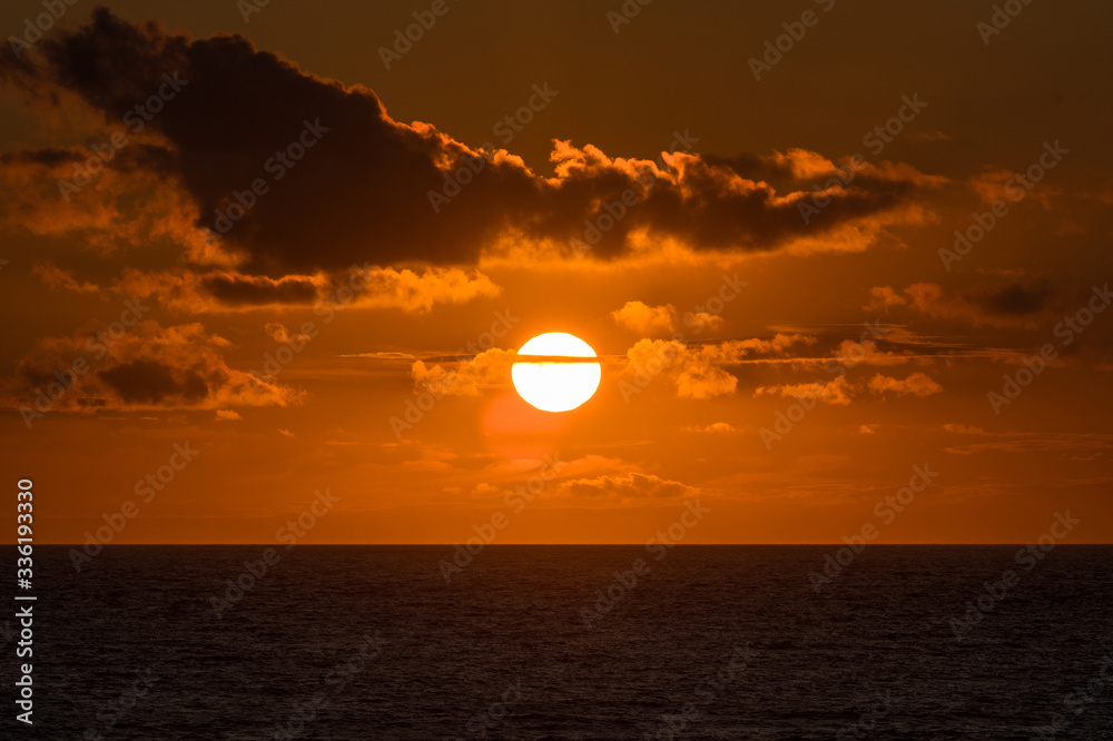 Sun setting above the horizon on a late summers evening.  Taken out to sea from Croyde Bay, UK