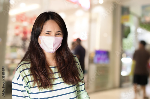 Asian woman wearing face mask and smiling