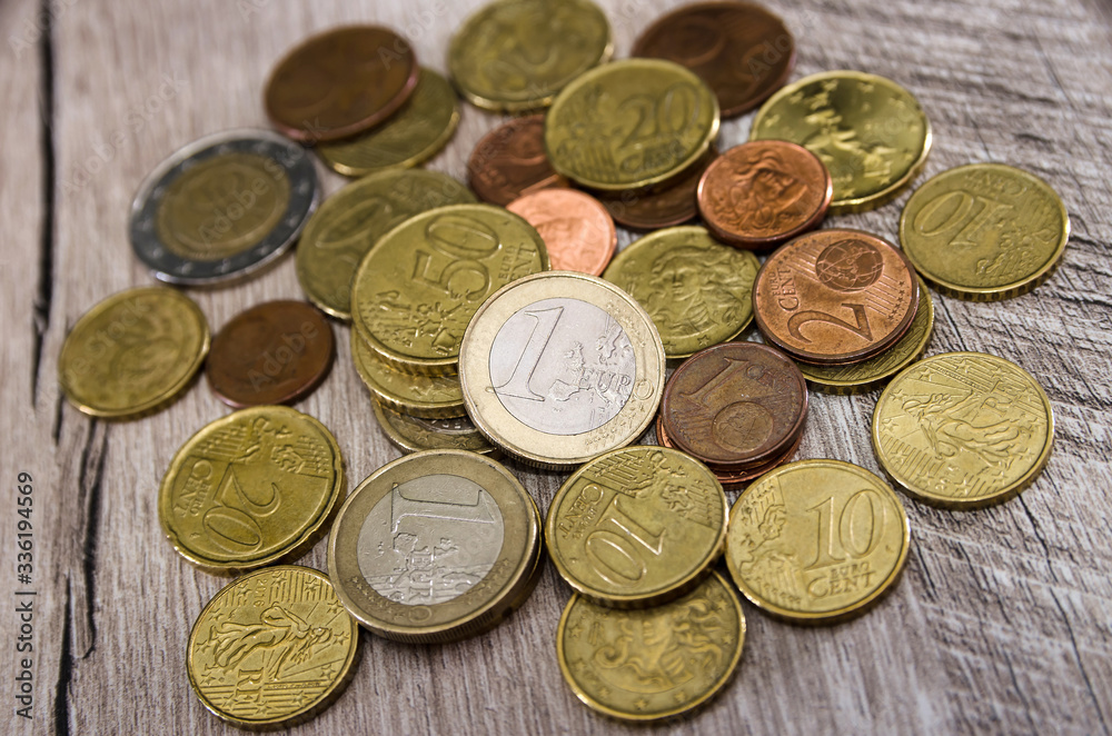 Coins on a wooden background. A pile of coins on the table. Close-up. Coins on a wooden background. A pile of coins on the table. Close-up.