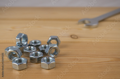 Metalowe nakrętki na desce drewnianej