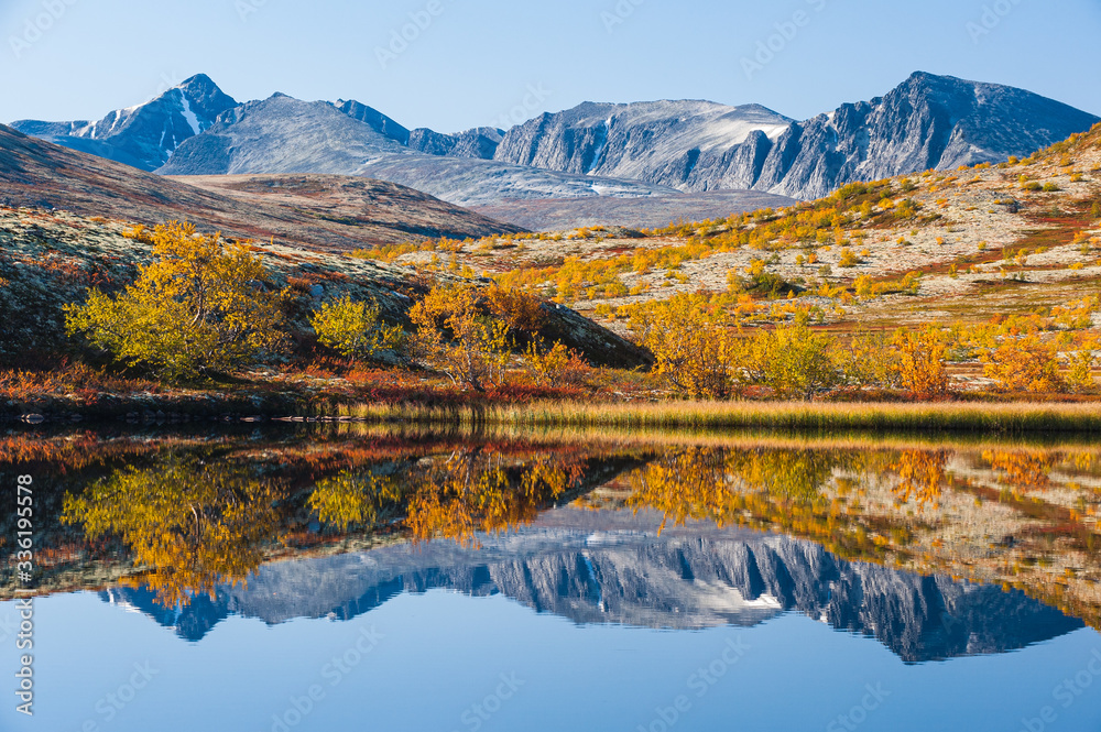 Obraz premium Mountain reflection on calm lake at autumn, Norway.