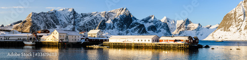 Harbor with buildings in front of snow covered mountains, Norway.