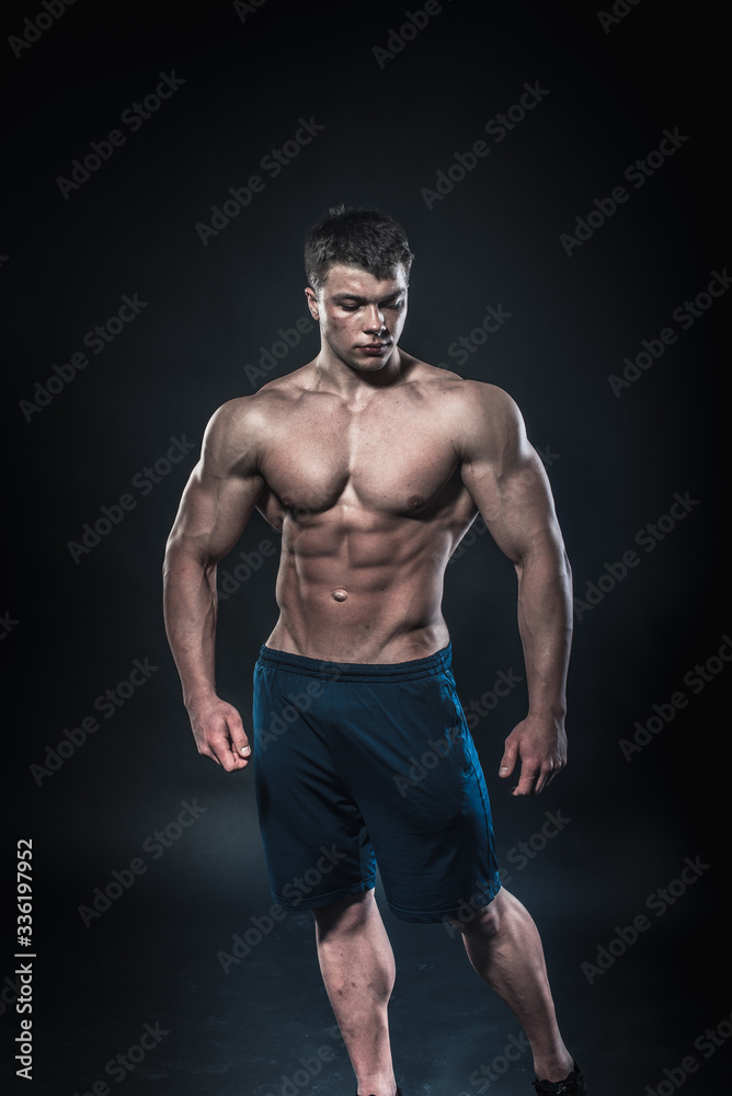 Sexy young athlete posing on a black background in the Studio. Fitness, bodybuilding Sexy young athlete posing on a black background in the Studio. Fitness, bodybuilding