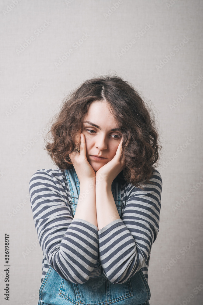 The woman thought, sad, thinking, emotions. On a gray background. The woman thought, sad, thinking, emotions. On a gray background.