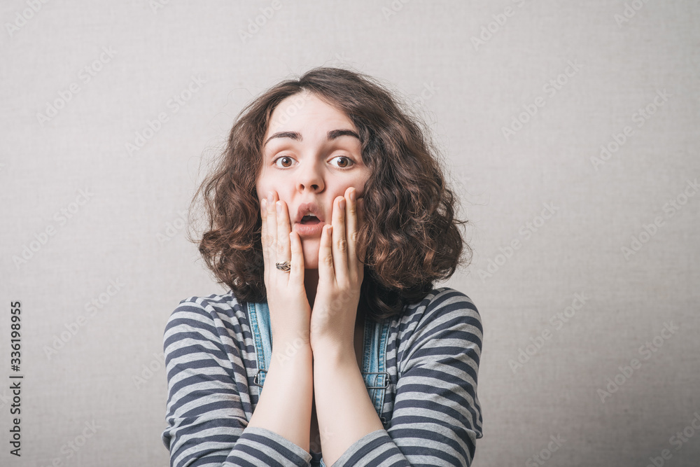 The woman thought, sad, thinking, emotions, fear. On a gray background.
