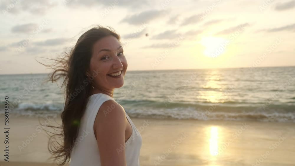 cheerful young lady with long loose hair in white dress runs along empty ocean shore to water at sunset slow motion cheerful young lady with long loose hair in white dress runs along empty ocean shore to water at sunset slow motion