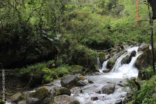 Beautiful landscape of cascade falls over mossy rocks, stones cover with moss, in a Mountain in Sichuan, China