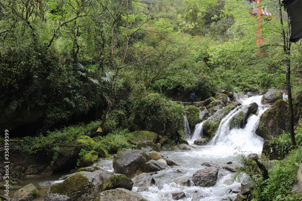 Beautiful landscape of cascade falls over mossy rocks, stones cover with moss, in a Mountain in Sichuan, China Beautiful landscape of cascade falls over mossy rocks, stones cover with moss, in a Mountain in Sichuan, China