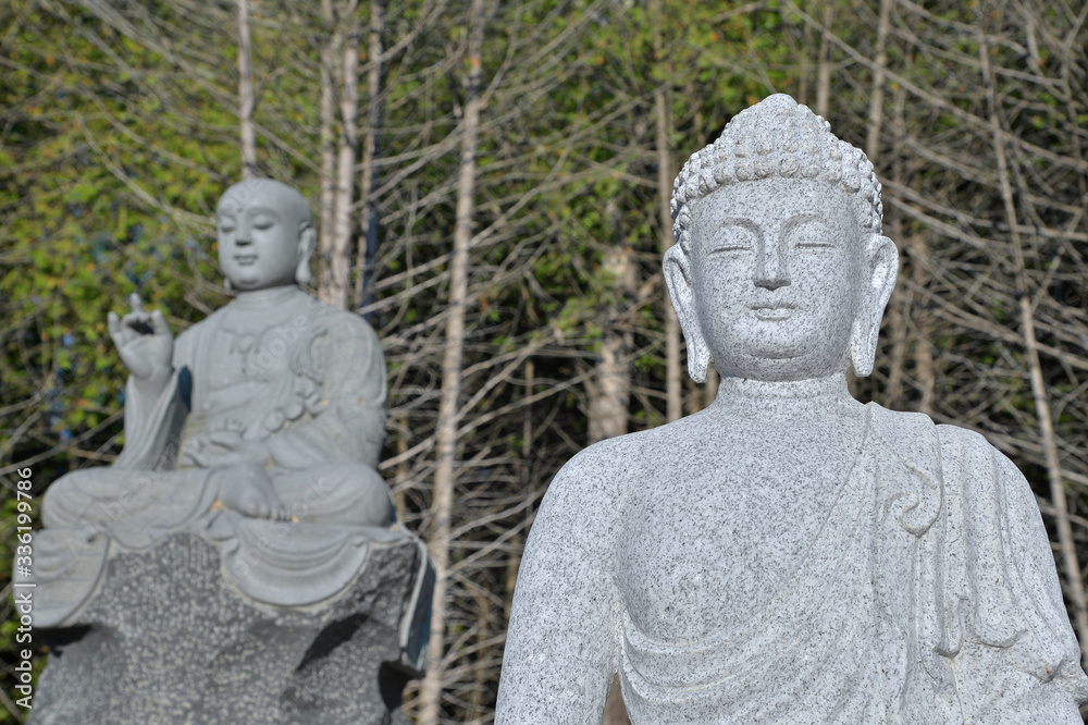 Stone statue of Buddha at buddhist temple in Bethany, Ontario, Canada