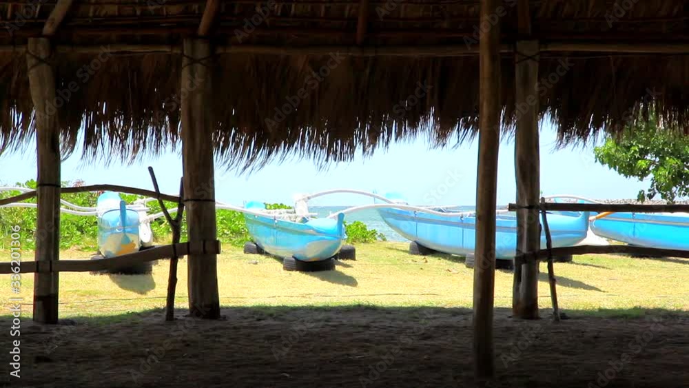 Canoes at Kahului Harbor on Maui as seen from inside a grassroofed